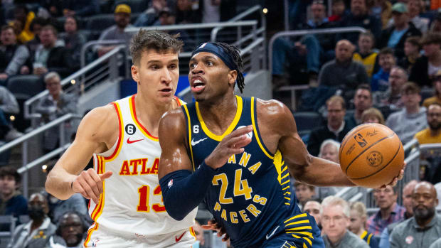 Pacers guard Buddy Hield dribbles past Hawks guard Bogdan Bogdanovic.